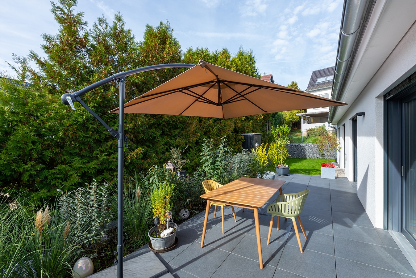 Walmdachbungalow-terrasse-mit-outdoor-moebeln-und-sonnensegel